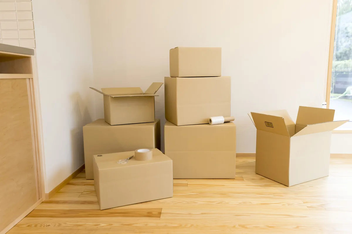 片付いた部屋に積まれた引っ越し用の段ボール箱