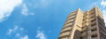 青空の下に建つマンション群、都市の住宅街の様子