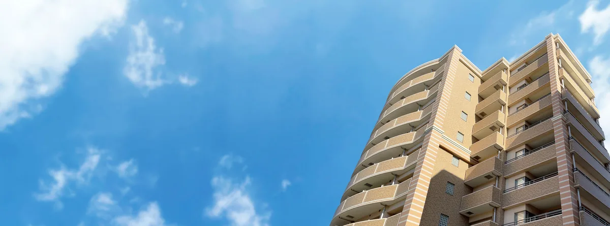 青空の下に建つマンション群、都市の住宅街の様子