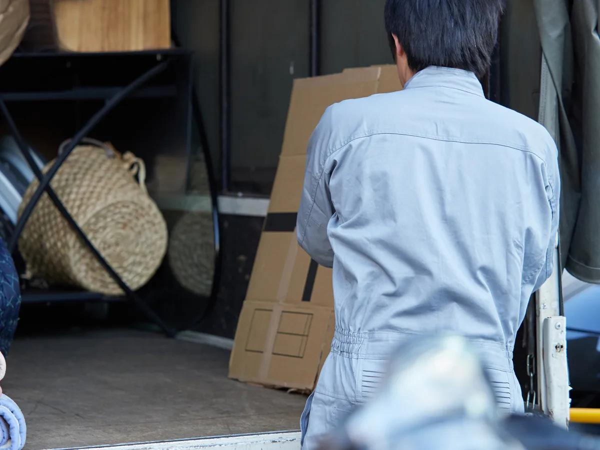 軽トラックの荷台に粗大ごみを積み込んでいる様子