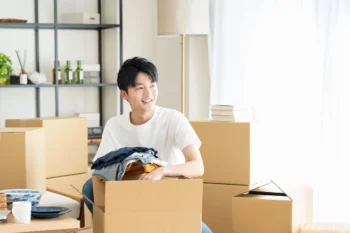 片付いた部屋に積まれた段ボール箱と荷物整理の様子