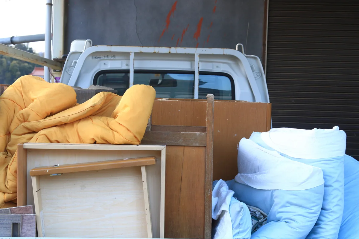 軽トラックの荷台に家具を積み込んで運ぶ様子