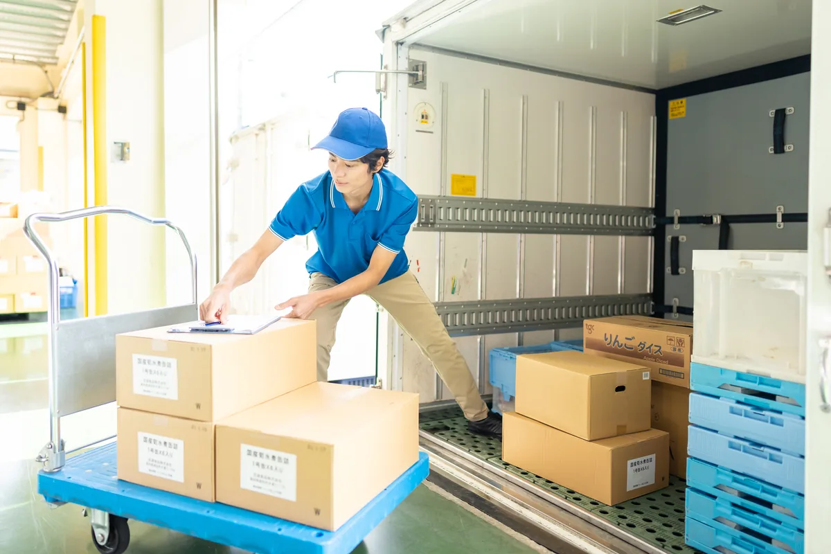 粗大ごみの家具をトラックの荷台に積み込む作業の様子