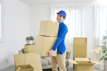 片付いた部屋で段ボール箱を運び出す様子