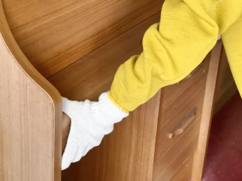 男性が椅子などの家具を運び出している様子