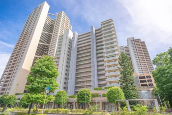 青空の下に建つマンションと住宅街の街並み