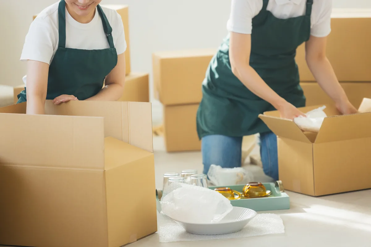 片付いた部屋に積まれた段ボール箱と荷造りの様子