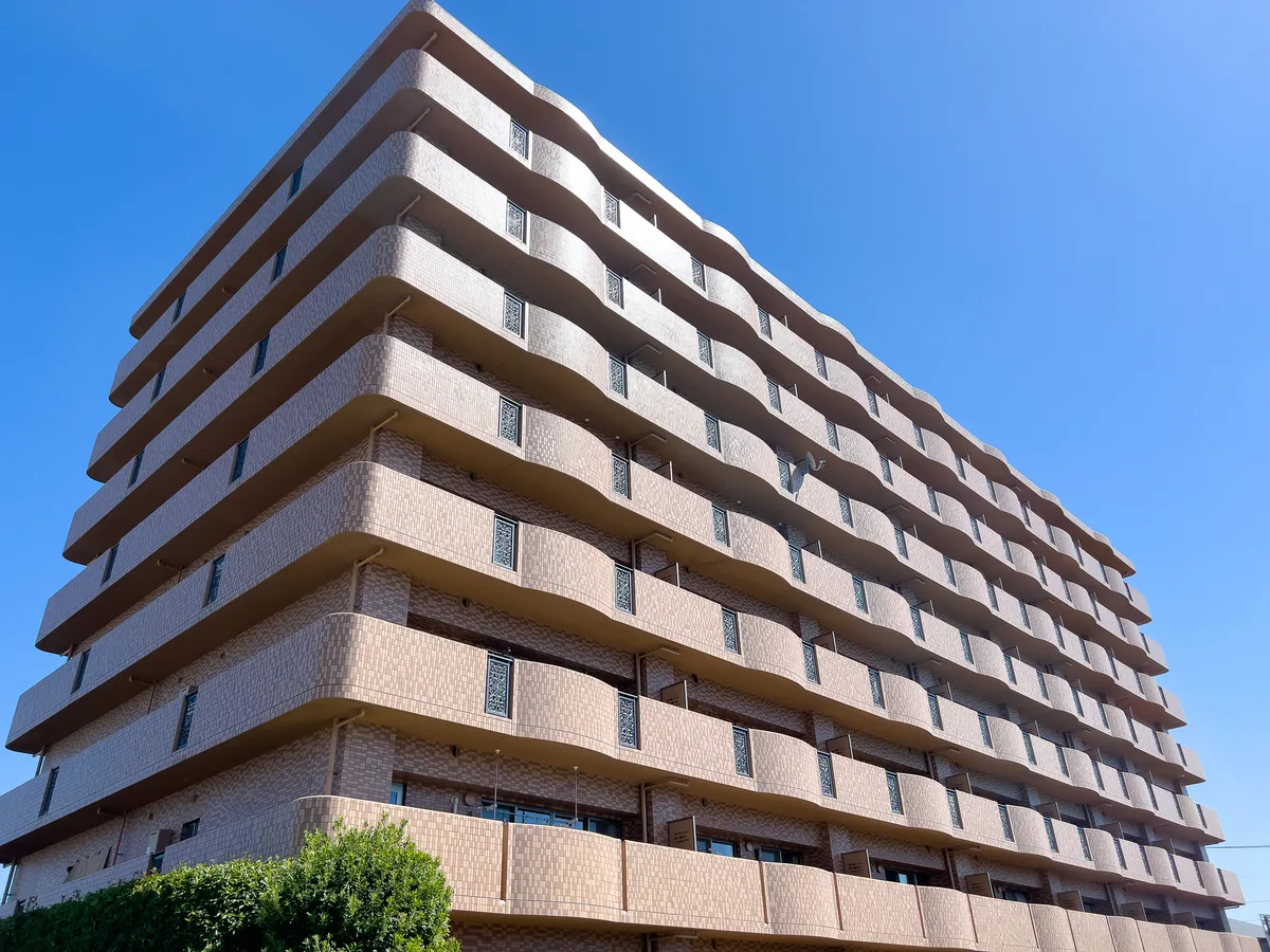 都市部に建ち並ぶマンションの外観と青空の風景
