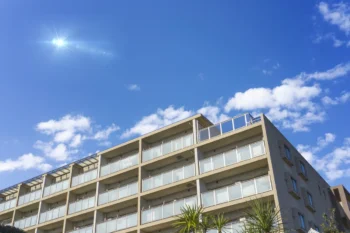 都市部に建ち並ぶマンションの外観と青空の風景