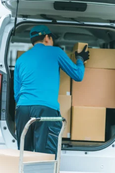軽トラックの荷台に家具を積み込んでいる様子