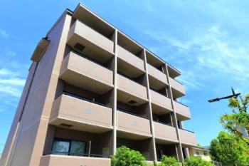 青空の下に立つマンションと住宅街の街並み